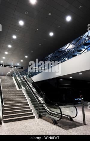 Beleuchteter Flughafen Zürich mit Eskalator bei Nacht im Flughafen Kloten, Zürich, Kanton Zürich, Schweiz Stockfoto
