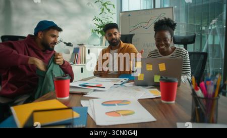 Drei Geschäftsmitarbeiter Teambesprechung Besprechungsbüro diskutieren mit Laptop die Ergebnisse von Dokumenten und lösen das Problem des Finanzbudgets des Unternehmens. Lächelnd Stockfoto