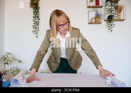 Architektin studiert Bauplan für ein neues Bauprojekt Stockfoto