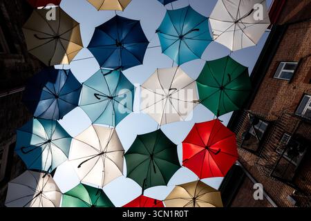 Farbenfrohe Regenschirme hängen über einer Straße im Viertel Petit-Champlain von Quebec City, Kanada. Stockfoto