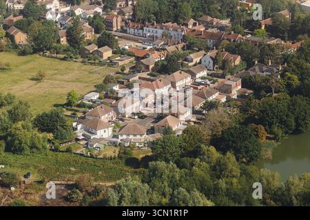Luftaufnahme von Vorstadthäusern. Wohnviertel mit Dächern. Landschaft in der Nähe von Wald und Wasser. Landschaftlich reizvolle Immobilienviertel Stockfoto