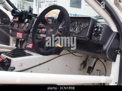 Racing Cockpit eines Rallye-Autos – das Innencockpit eines Oldtimer-Rallye-Autos mit Lenkrad, Armaturenbrett mit Anzeigen, Sicherungstafel und Pedalen Stockfoto