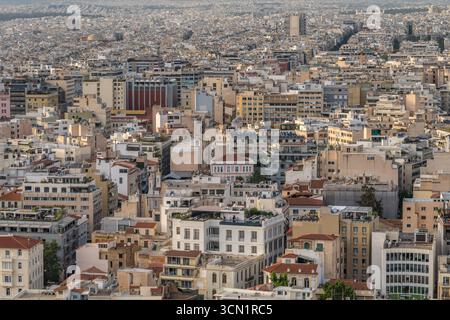 Breiter Panoramablick über das Zentrum von Athen mit einer dichten Verteilung von Dächern und mittelhohen Gebäuden, die sich bis zum fernen Horizont, Griechenland, erstrecken. Mai 2025 Stockfoto