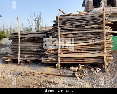 Ein großer Stapel von rauen Holzdielen und Baumstämmen, die im Freien ordentlich angeordnet sind und häufig für Bau- und Bauzwecke verwendet werden. Stockfoto