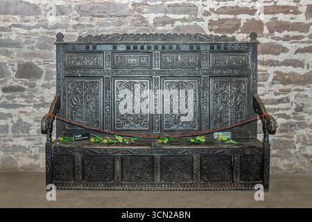Vereinigtes Königreich - Doune - Doune Castle - eine Bank aus Eiche, die mit Kalkstein bedeckt ist, sowie Platten und Armlehnen, die zu einem tiefen Glanz getragen wurden Stockfoto