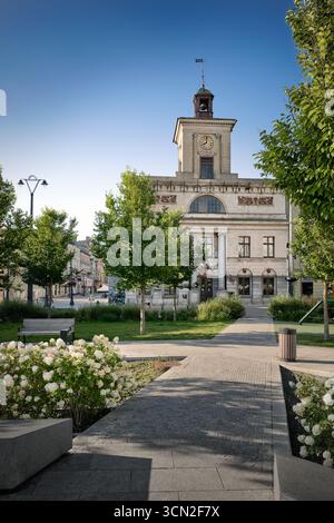 Lodz, Polen - 17. August 2025: Freiheitsplatz (Plac Wolnosci) mit historischem Rathaus und städtischem Grün im Zentrum von Lodz Stockfoto