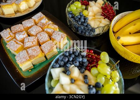 Eine köstliche Auswahl an Desserts und eine lebhafte Auswahl an frischem Obst Stockfoto