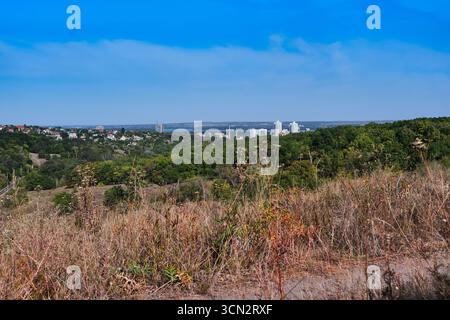 Sonnenuntergang über dem Tunnel Beam Park in Dnipro, Ukraine – goldenes Licht, das am 16. September 2025 durch Bäume filtert Stockfoto