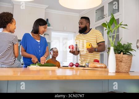 Vielfältige Familiengemüse auf einer Holzkücheninsel unter Hängeleuchten mit frischen Produkten Stockfoto