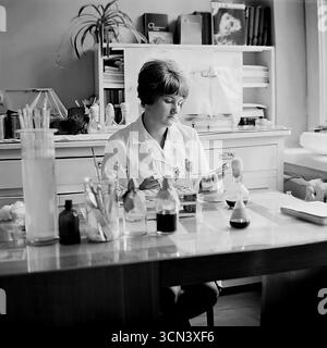Ein historisches Foto aus den 1970er-80er Jahren, das eine Laborassistentin zeigt, die in einem wissenschaftlichen Labor im Ferienort Slavkurort (Sloviansk, Ukrainische SSR) arbeitet. Der Spezialist für einen weißen Fell konzentriert sich auf die Durchführung einer chemischen Analyse oder Forschung mit Pipetten und Kolben, um die wichtige Rolle der Frauen in der sowjetischen Wissenschaft und die technische Grundlage des berühmten Kurortes zu veranschaulichen Stockfoto