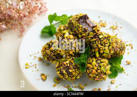 Dunkle Schokoladentrüffel, bedeckt mit sizilianischen Pistazien. Stockfoto