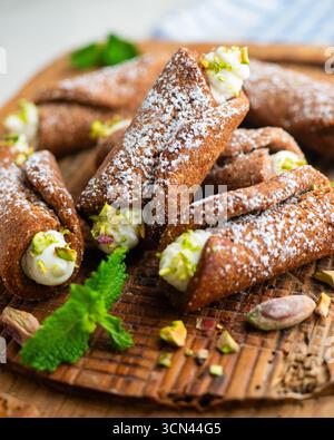 Sizilianische Cannoli gefüllt mit Ricotta-Käse-Sahne und garniert mit gehackten Pistazien. Stockfoto
