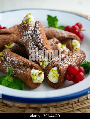 Sizilianische Cannoli gefüllt mit Ricotta-Käse-Sahne und garniert mit gehackten Pistazien. Stockfoto