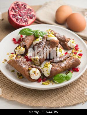 Sizilianische Cannoli gefüllt mit Ricotta-Käse-Sahne und garniert mit gehackten Pistazien. Stockfoto