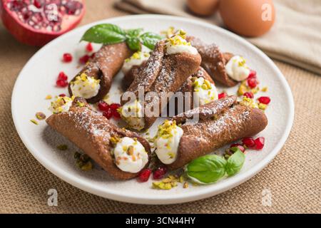 Sizilianische Cannoli gefüllt mit Ricotta-Käse-Sahne und garniert mit gehackten Pistazien. Stockfoto