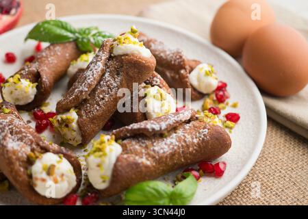 Sizilianische Cannoli gefüllt mit Ricotta-Käse-Sahne und garniert mit gehackten Pistazien. Stockfoto