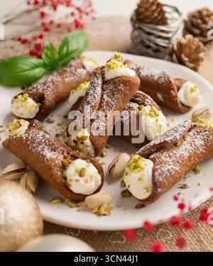 Sizilianische Cannoli gefüllt mit Ricotta-Käse-Sahne und garniert mit gehackten Pistazien. Stockfoto