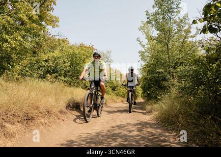 Zwei Radfahrer genießen an einem sonnigen Tag eine malerische Wanderung durch üppiges Grün Stockfoto