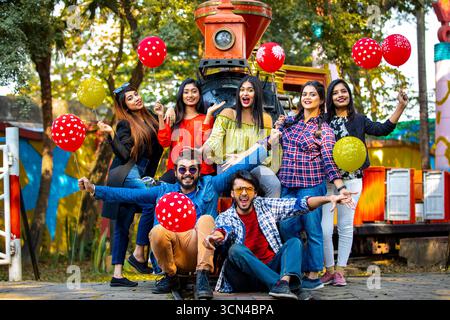 Gruppe von Freunden, die mit Ballons im Vergnügungspark feiern - Fun Group Porträt Stockfoto
