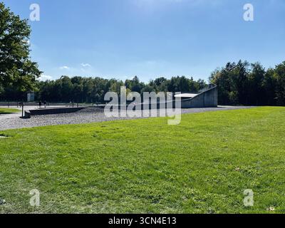 Dachau, Deutschland - 29. September 2022: Statue und Pfad am KZ-Gedenkort Dachau umgeben von grünem Gras und Bäumen. Stockfoto