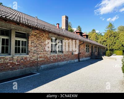 Dachau, Deutschland - 29. September 2022: Ziegelbau im Konzentrationslager Dachau begleitet von klarem Himmel und Bäumen. Stockfoto