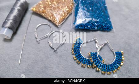 Handgefertigte Ohrringe mit Perlen und Glasperlen auf hellem Hintergrund. Produktvorführung. Modetrends. Kopierbereich Stockfoto