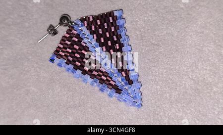 Handgefertigte Ohrringe mit Perlen und Glasperlen auf hellem Hintergrund. Produktvorführung. Modetrends. Kopierbereich Stockfoto