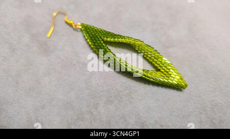 Handgefertigte Ohrringe mit Perlen und Glasperlen auf hellem Hintergrund. Produktvorführung. Modetrends. Kopierbereich Stockfoto