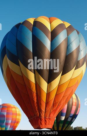 Bunte Heißluftballons vor einem leuchtend blauen Himmel Stockfoto