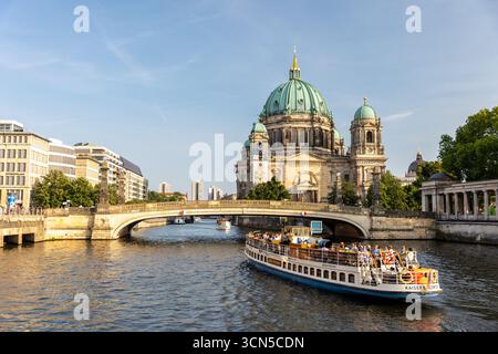 Berlin, Deutschland - 9. August 2025: Der majestätische Berliner Dom erhebt sich über der Spree. Besichtigungstour Boot volle Touristenpässe Stockfoto