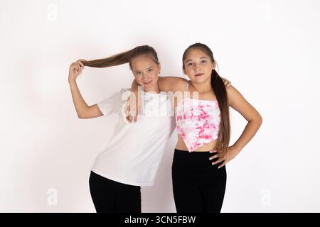 Mädchen in weißen Hemden und schwarzen Hosen posieren für die Kamera Stockfoto