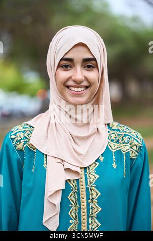 Lächelnde junge muslimische Frau in traditioneller Kleidung Stockfoto
