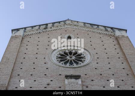 Blick auf das Rosenfenster und die Ziegelfassade steigen in Richtung eines hellen Himmels, die antiken Steine der Kirche flüstern Geschichten über Geschichte und Glauben, Chieti, Abruzzen, Italien. Stockfoto