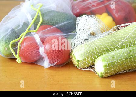 Frische Ernte: Buntes Gemüse in wiederverwendbaren Säcken. Tomaten, Paprika, Gurken und Kürbis, Symbol der lokalen Landwirtschaft und gesunden Ernährung Stockfoto