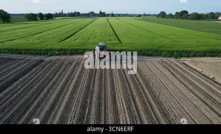 Piacenza, Italien - 23. April 2023 Eine Gruppe von Bauern steht stolz vor ihrem modernen Traktor nach einem langen Tag mit fruchtbaren Feldern und Stockfoto