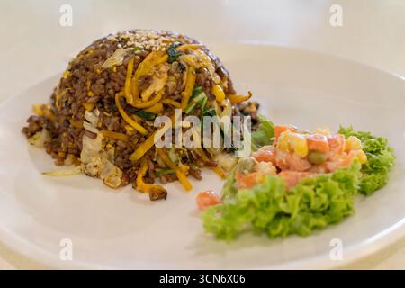 Köstliches Reisgericht mit Kürbis, gemischt mit Gemüse und frischer Salatgarnitur. Stockfoto