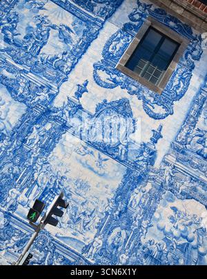 Portugal, Porto, Seitenwand der Azulejo-verkleideten Capela das Almas oder Kapelle der Seelen aus dem 18. Jahrhundert, auch bekannt als Kapelle Santa Catarina mit 15.947 Azulejo-Fliesen, die von Eduardo leite entworfen wurden. Stockfoto