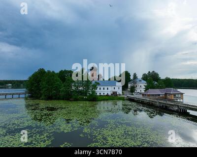 Ein flacher Blick aus der Vogelperspektive auf das Kloster der Insel Vvedenski, das die Gebäude und Fußgängerbrücken zeigt, die die Insel mit der üppigen grünen Küste verbinden. Stockfoto