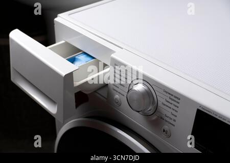 Nahaufnahme einer Waschmittelschublade für Waschmaschinen mit blauem Pad innen und Bedienfeld in russischer Sprache. Ideal für Gerät, Wäsche und ho Stockfoto