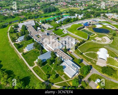 Ein Hochwinkelfoto eines großen Resortkomplexes in Suzdal, der eine Mischung aus modernen und älteren Gebäuden, einem Wasserpark und üppigen grünen Feldern zeigt. Stockfoto