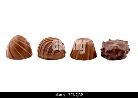 Vier Schokoladenbonbons in verschiedenen Formen und Größen. Die Süßigkeiten sind in einer Reihe auf weißem Hintergrund angeordnet Stockfoto