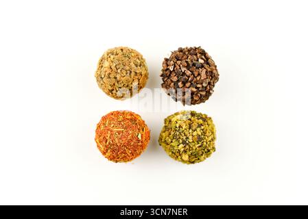 Vier verschiedenfarbige Kugeln Essen. Die Farben sind gelb, orange, grün und braun. Die Kugeln sind in einem Quadrat angeordnet Stockfoto
