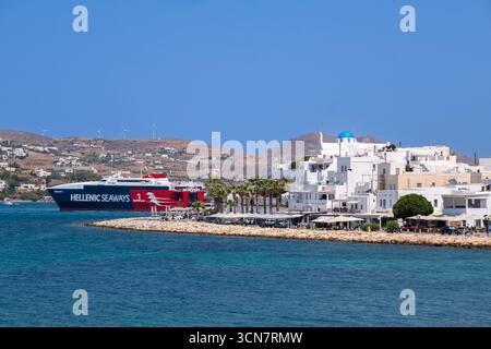 Parikia, Paros, GR - 22. August 2025: Allgemeiner Blick auf die Küste von Parikia mit einer Hellenic Seaways Fähre im Hintergrund Stockfoto