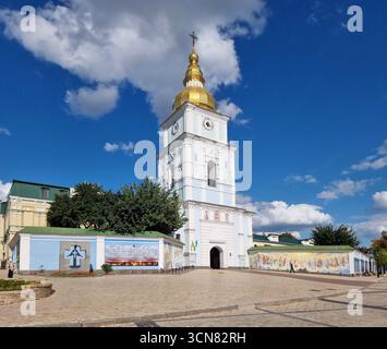 Blick auf das Kloster St. Michaels mit goldener Kuppel in Kiew vom Mykhailivska-Platz mit dem Glockenturm im Vordergrund. Sonniger Sommertag mit blauem Himmel und Stockfoto