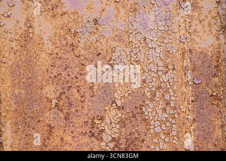 Nahaufnahme von rostiger, rissiger violetter Farbe auf alter Metalloberfläche. Konzept des Grunge-Hintergrunds, des veralteten Materials und der industriellen Textur. Stockfoto