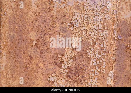 Nahaufnahme von rostiger, rissiger violetter Farbe auf alter Metalloberfläche. Konzept des Grunge-Hintergrunds, des veralteten Materials und der industriellen Textur. Stockfoto