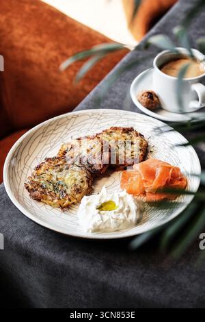 Ein köstlicher und zufriedenstellender Frühstücksteller mit frischem Lachs und hausgemachten Kartoffellatkes Stockfoto