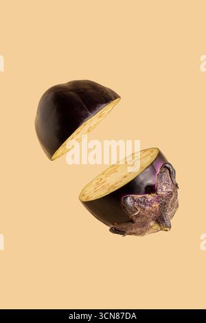 Auberginen geschnitten auf pastellrosa Hintergrund. Minimales Obst-Konzept. Weniger sehen Stockfoto