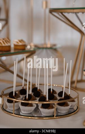 Elegantes Schokoladenkuchen-Display mit goldenen Akzenten für Feiern, Desserts und besondere Anlässe: Sattes Braun, weiß, luxuriöser Stil Stockfoto