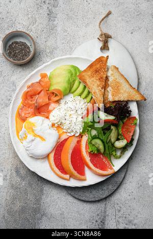 Ein gesunder Frühstücksteller mit Lachs, Avocado und einem perfekt pochierten Ei Stockfoto